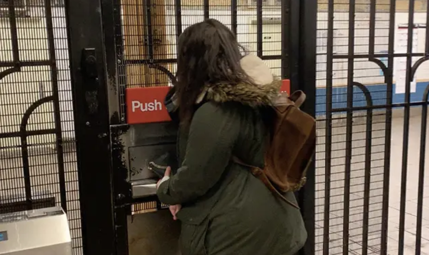 Woman opening emergency exit door in NYC subway station