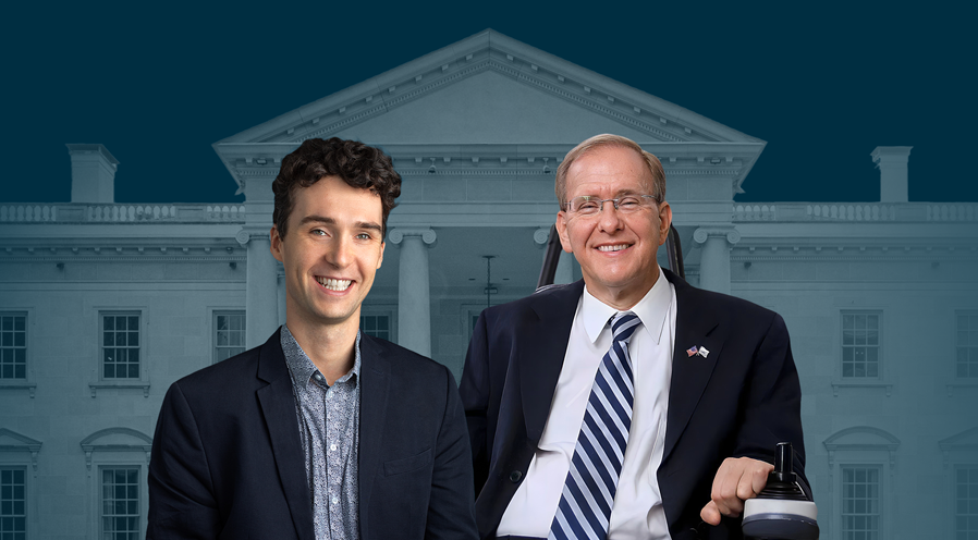 Alt text: "Two men, Congressman Jim Langevin (right) and Charles E. Catherine (left), appear in front of a faded image of the White House. Congressman Langevin, wearing a suit and tie, is seated in a wheelchair and smiling, while Charles E. Catherine, also in formal attire, smiles confidently beside him. The backdrop is a deep blue/green with a subtle view of the White House.