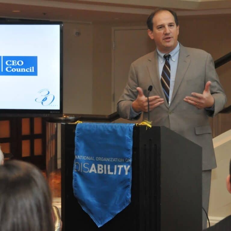NOD’s CEO Council member speaking in public behind a podium with a NOD logo branded across the front