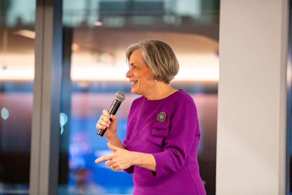 A women holding a microphone addressing a crowd