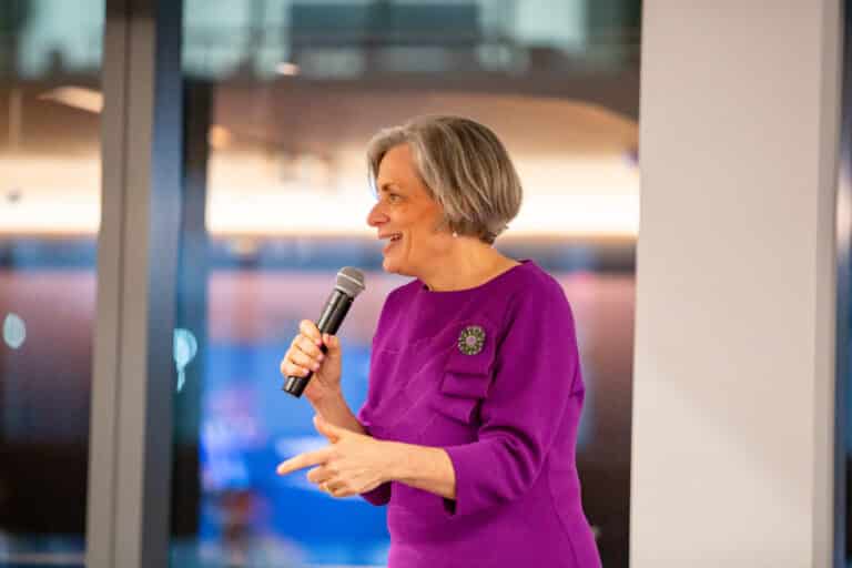 A women holding a microphone addressing a crowd