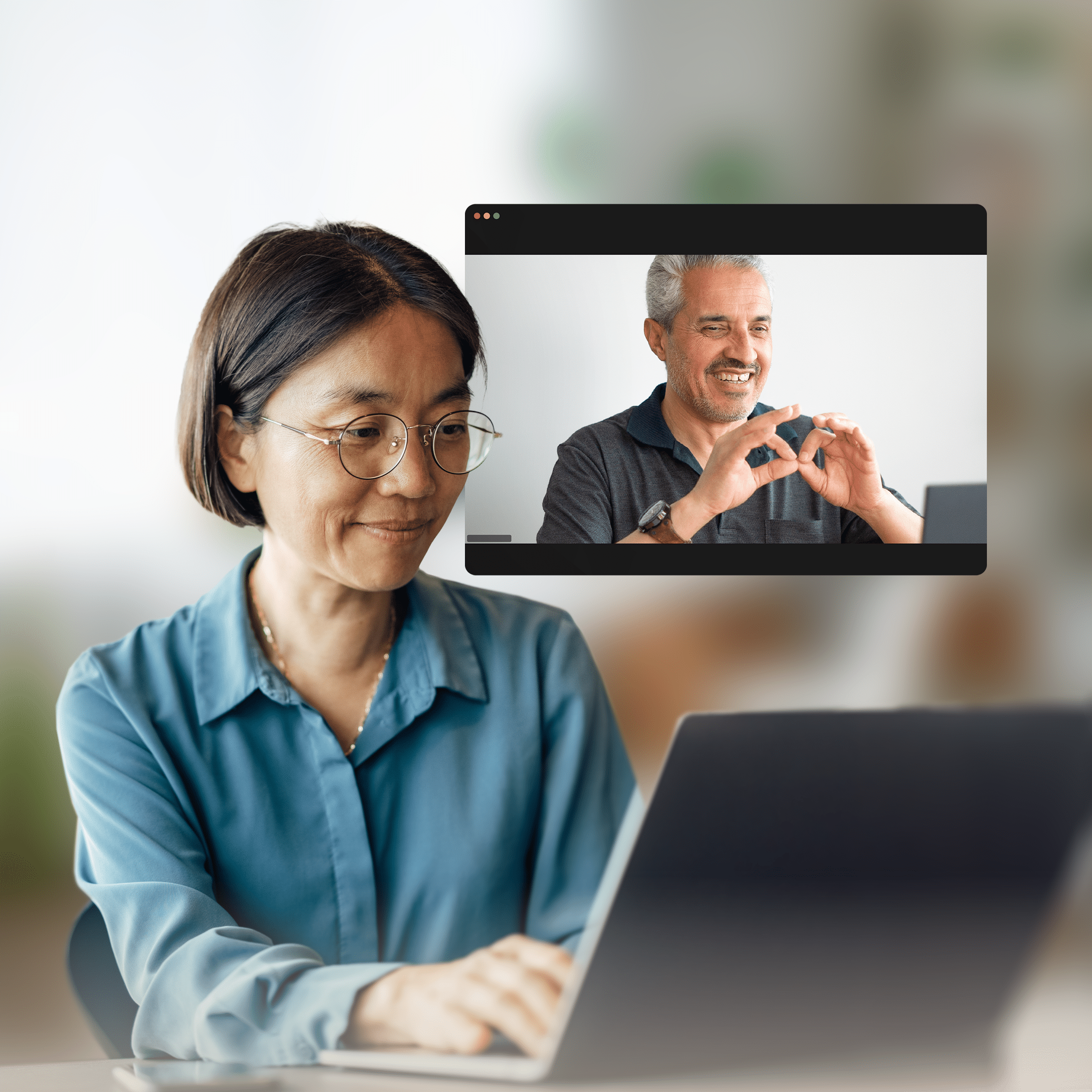 A woman works on a laptop while participating in a video call with a man using sign language.