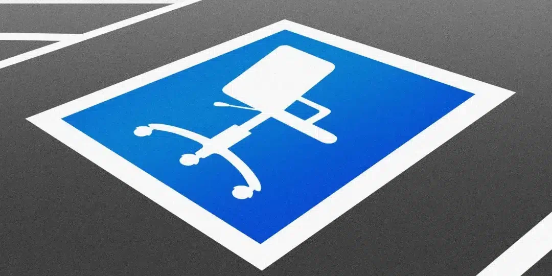 A silhouette of an office chair over a blue background, painted on a parking space