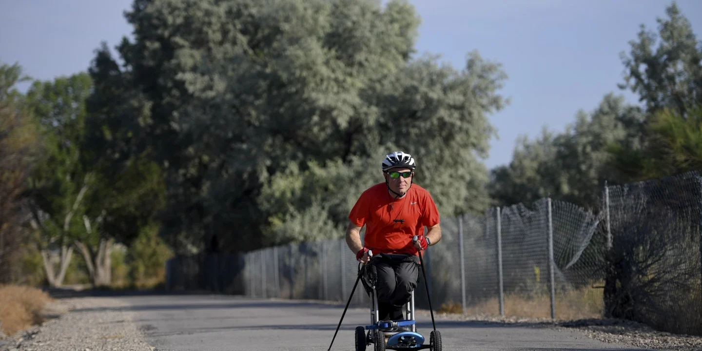 Kevin Hoyt rolls along down a paved road using a paraplegic-friendly mountainboard.