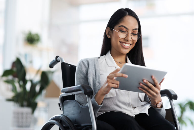Cropped Shot Of A Young Businesswoman In A Wheelchair Using Her Tablet In The Office