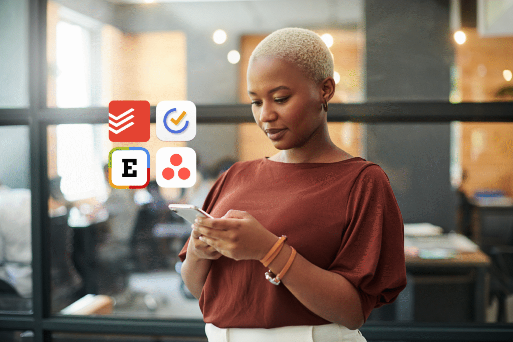 A woman with short blond hair wearing a rust-colored blouse stands indoors, looking at her smartphone. On the left side of the image are four app icons, including Todoist (red checkmark), TickTick (blue and yellow checkmark), Expensify (black “E” with colorful border), and Asana (three coral dots in a triangle). The background shows a blurred modern office with people working behind glass walls.