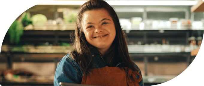 Younger smiling girl with down syndrome working in a market