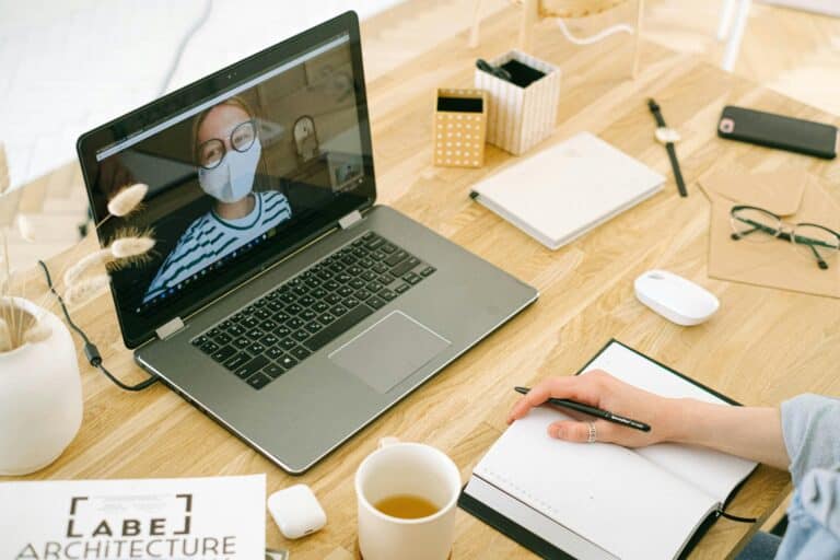A virtual meeting set up: the person on screen looks at the camera and wears a mask.