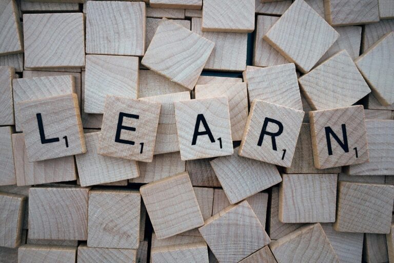 Scrabble pieces (small, square pieces of wood) that are laid out next to one another to spell LEARN.