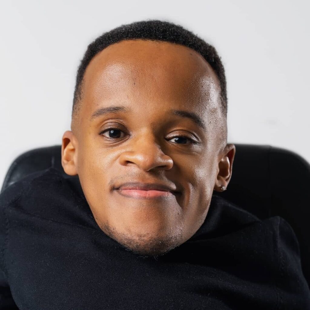 Close of headshot of Winston, a Black man with short black hair. He looks at the camera directly and smiles softly.