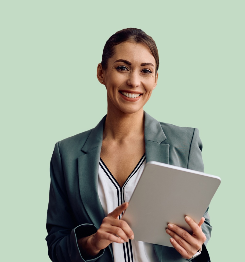 Smiling woman in a teal blazer holding a tablet against a pale green background. She's conveying a professional and positive demeanor.